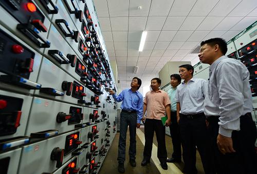 5月16日，在老挝首都万象的国家会议中心变配电室，中国建筑技术人员与老方工作人员检查设备运营情况。新华社发（刘艾伦摄）